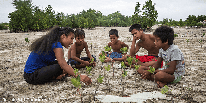Tinaai, explains to village children from Kiribati the importance of mangroves in protecting the country's shores from coastal erosion. Credit: Vlad Sokhin/Panos/OxfamAU