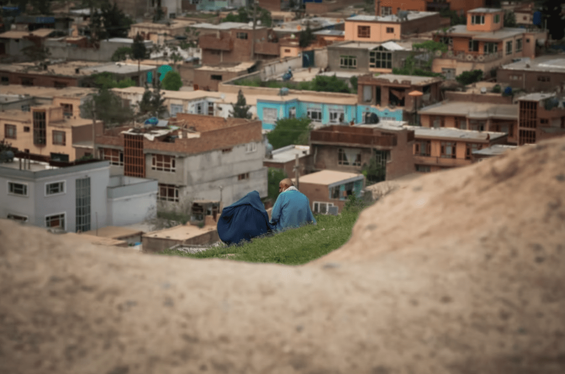 elderly couple sitting on mountain