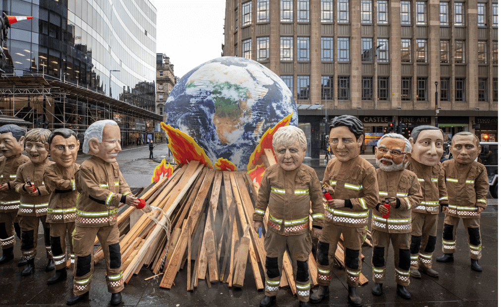 Image of people dressed as world leaders around a large earth above matches