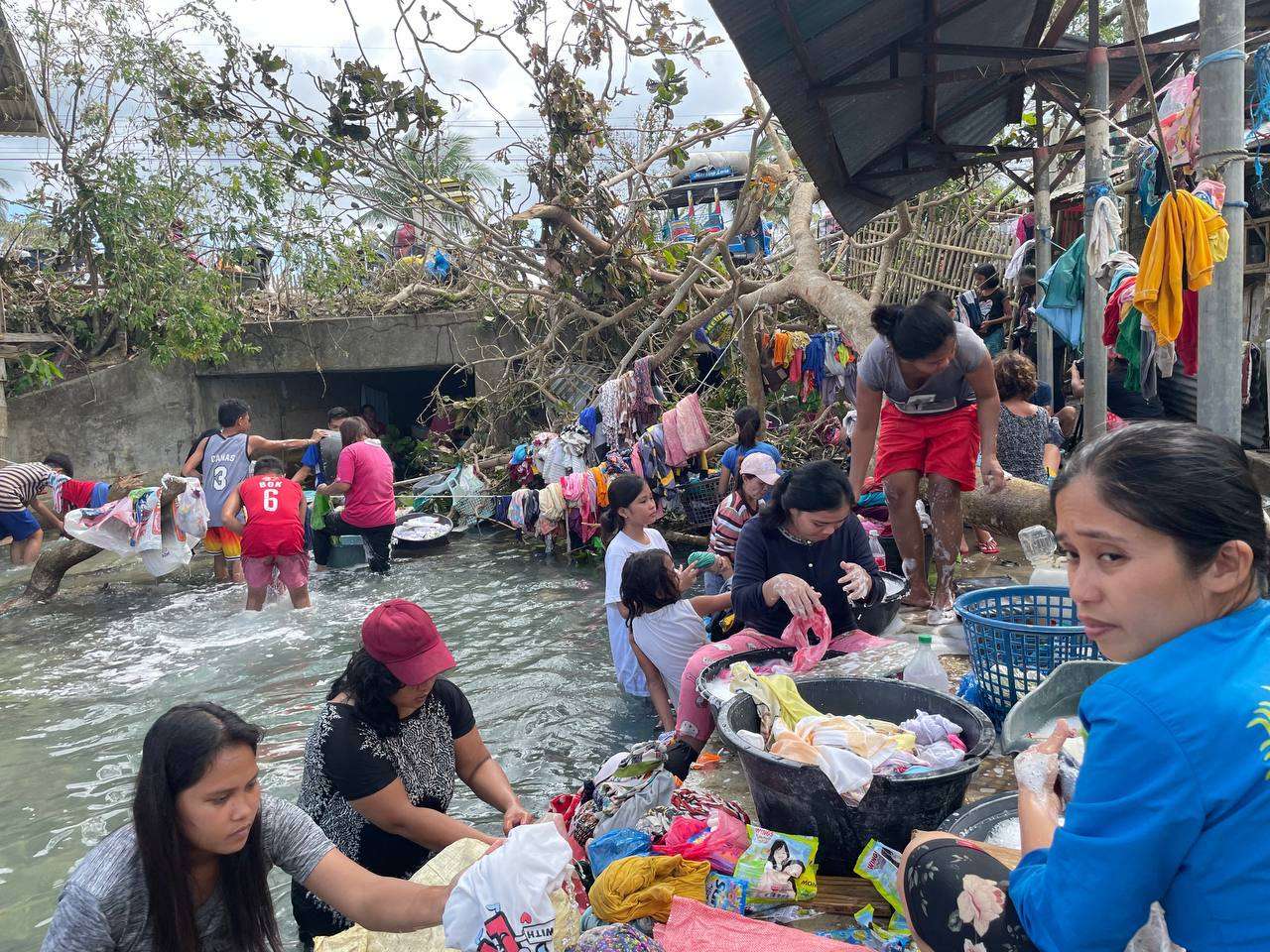 Group of people stand near flooded water