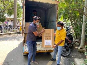Two men carry a box out of the back of a truck