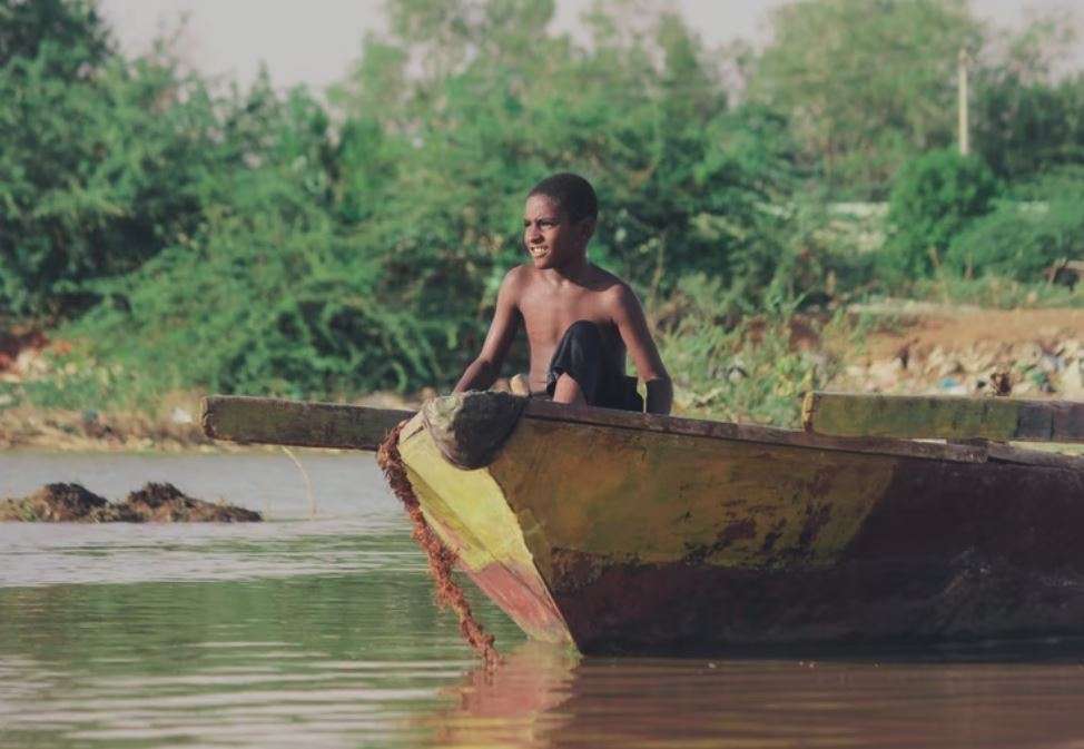 A boy sits in a boat