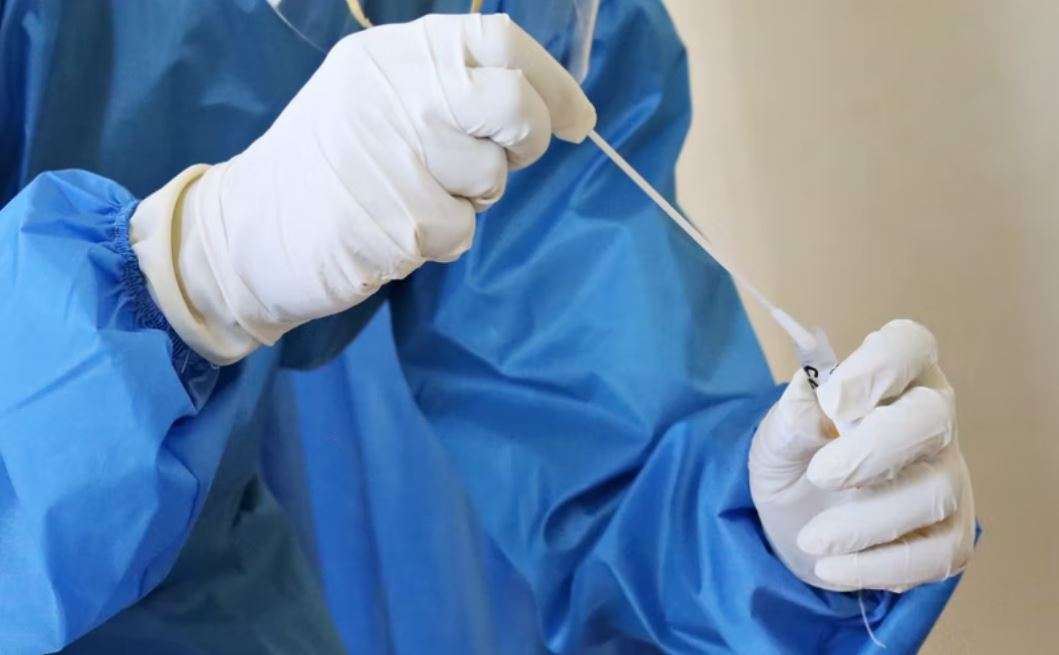 A health worker holds a Covid test swab
