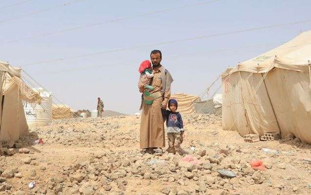 A father stands with his children