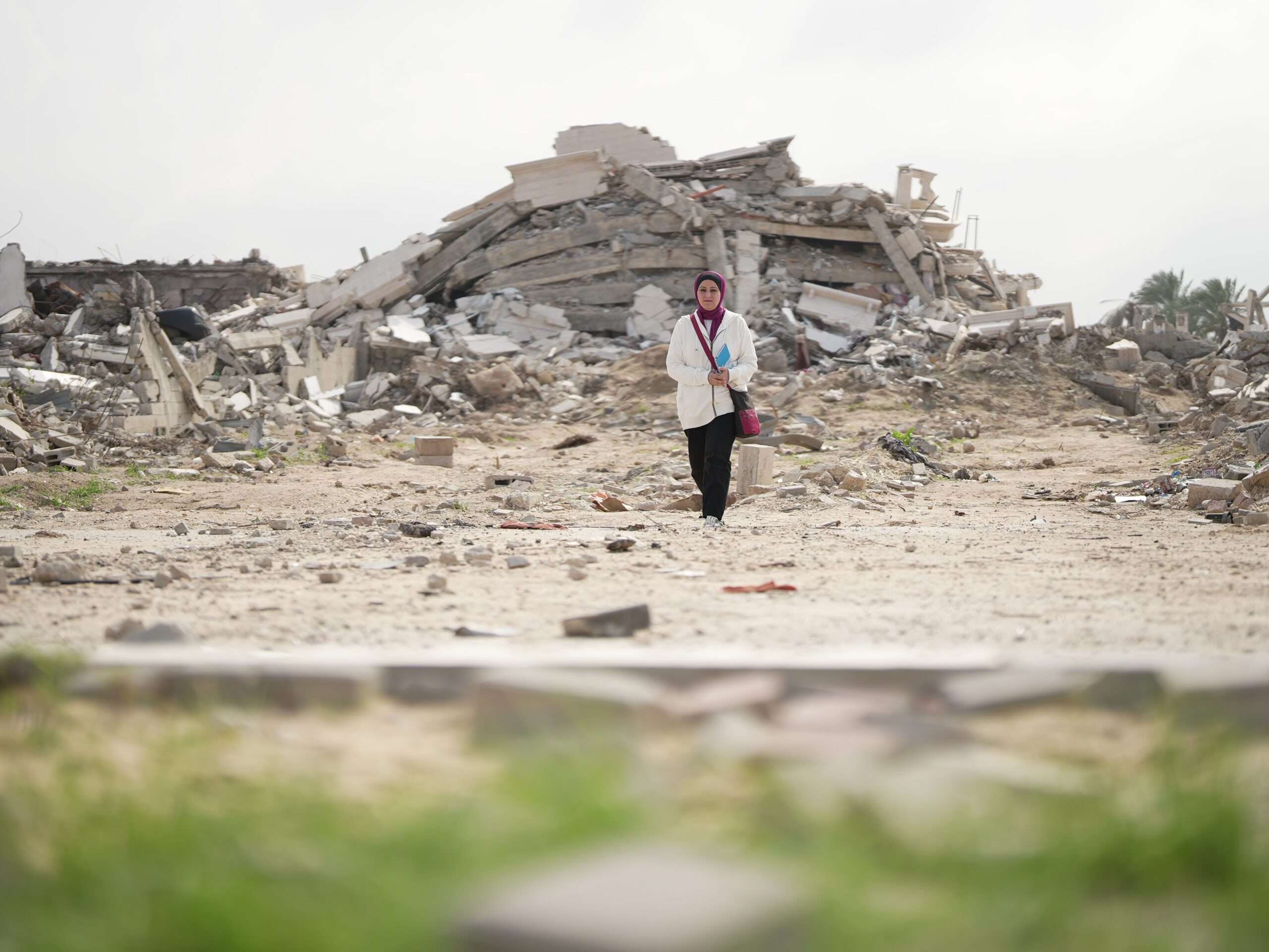 Fidaa Shurrab stands in front of rubble in the Gaza strip.