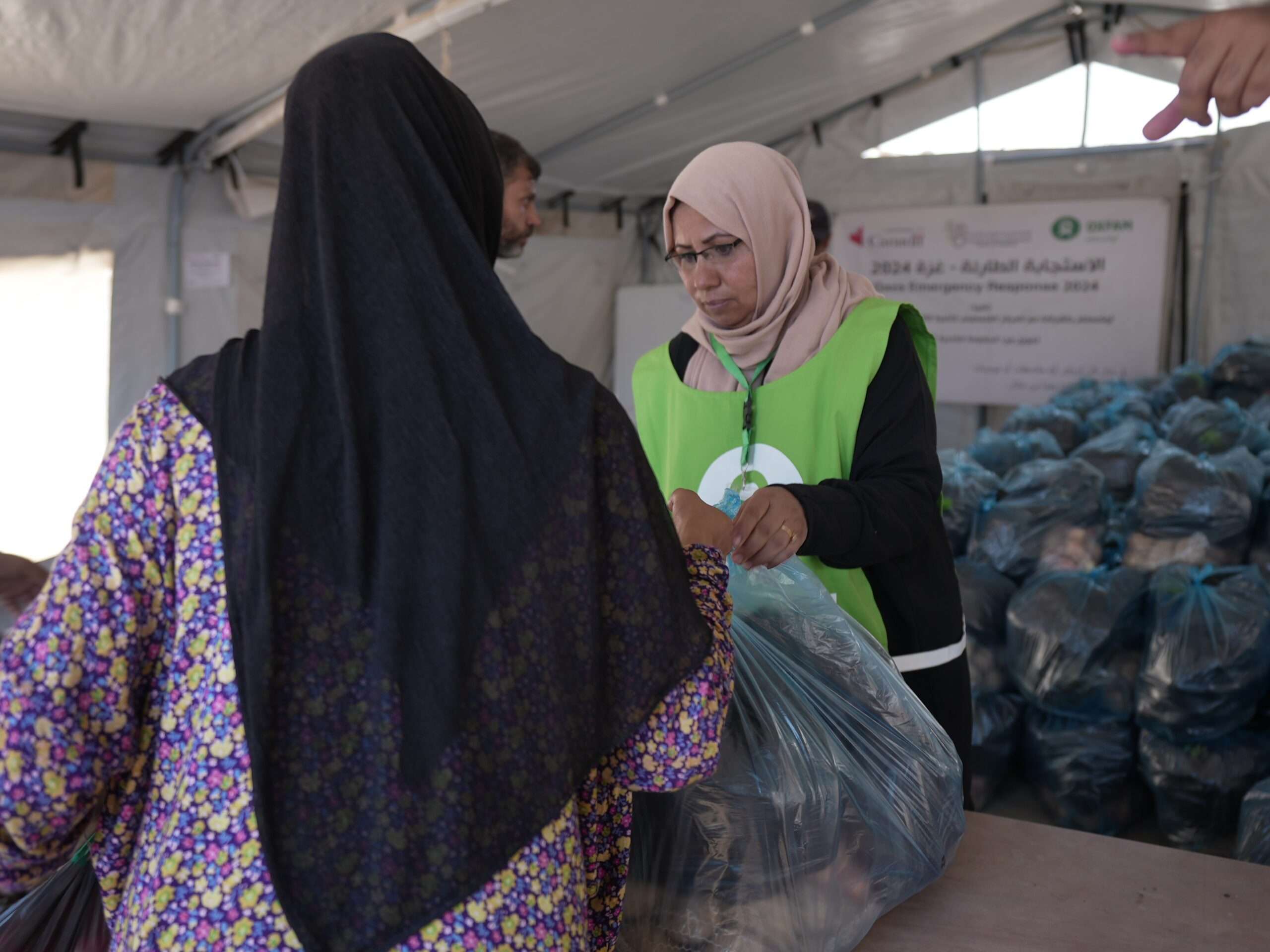 Oxfam workers giving vegetable packages to people in Gaza
