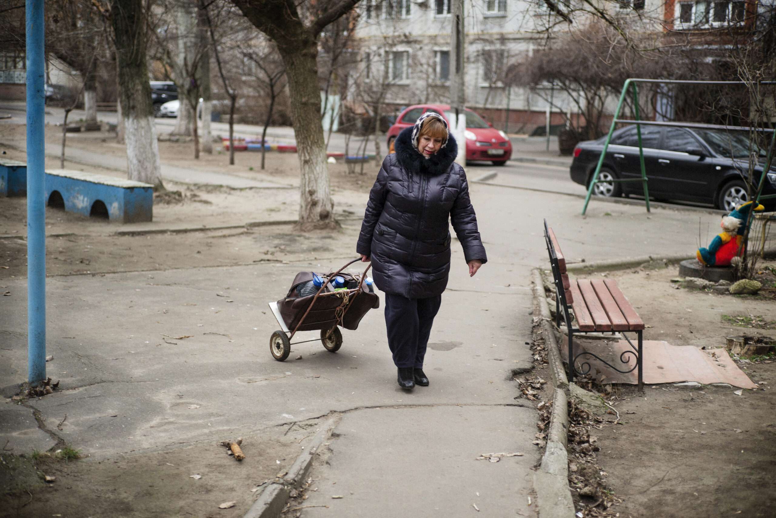 Larissisa pulls a small trolley filled with water bottles from Oxfam water points