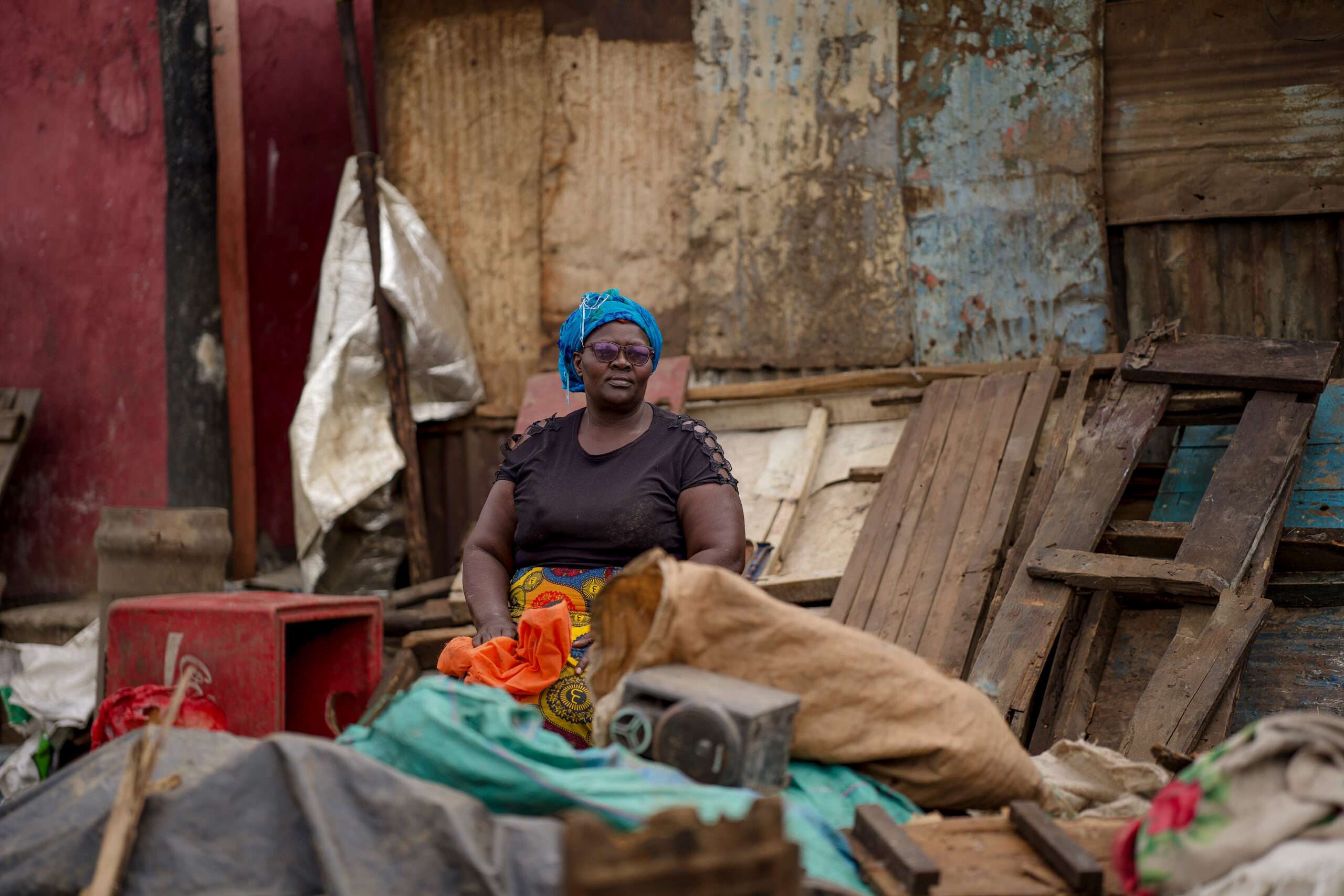Woman sitting outside demolised house in Kenya post flash floods