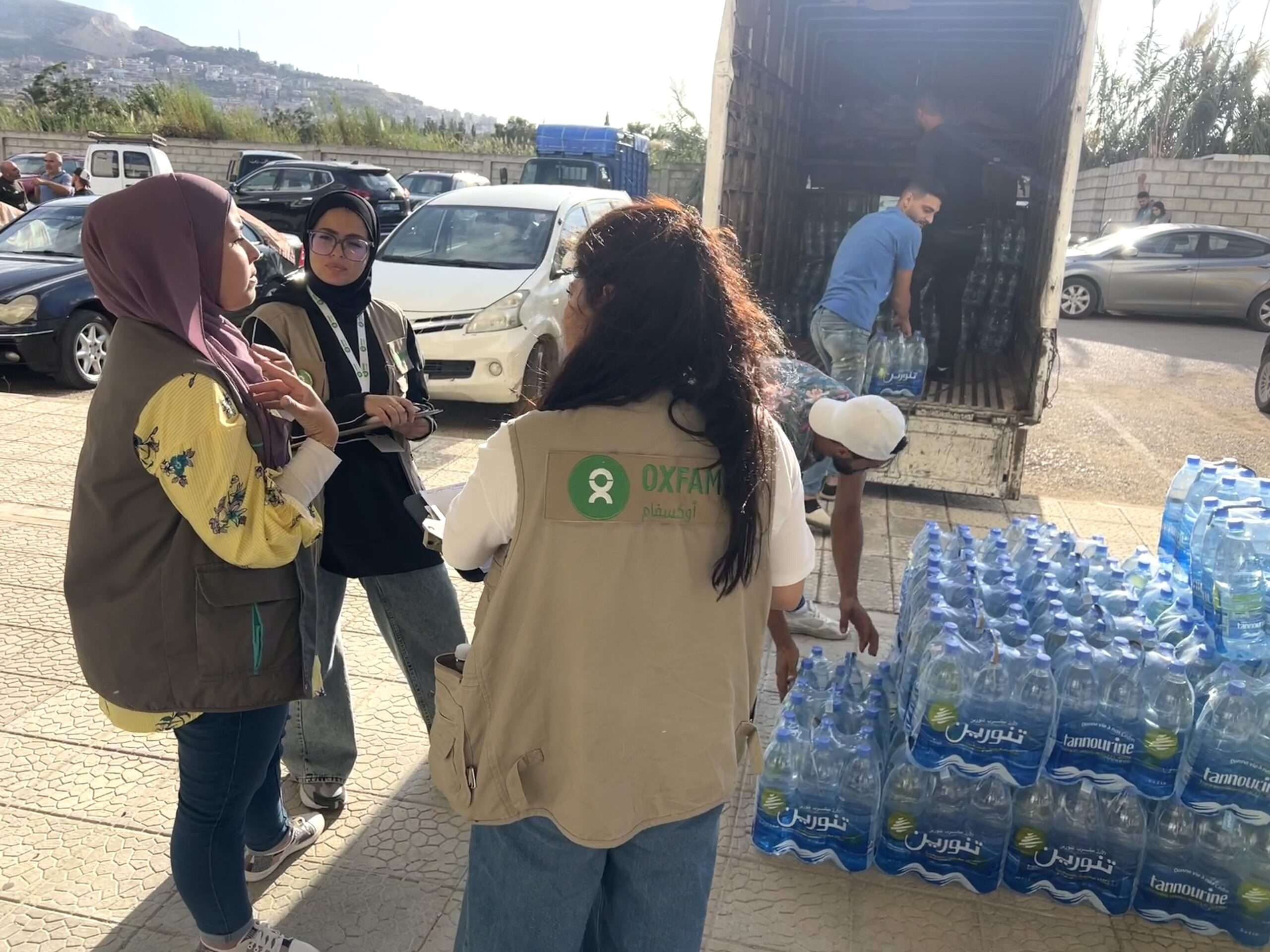 Oxfam unloading trays of water for displaced peoples in Gaza
