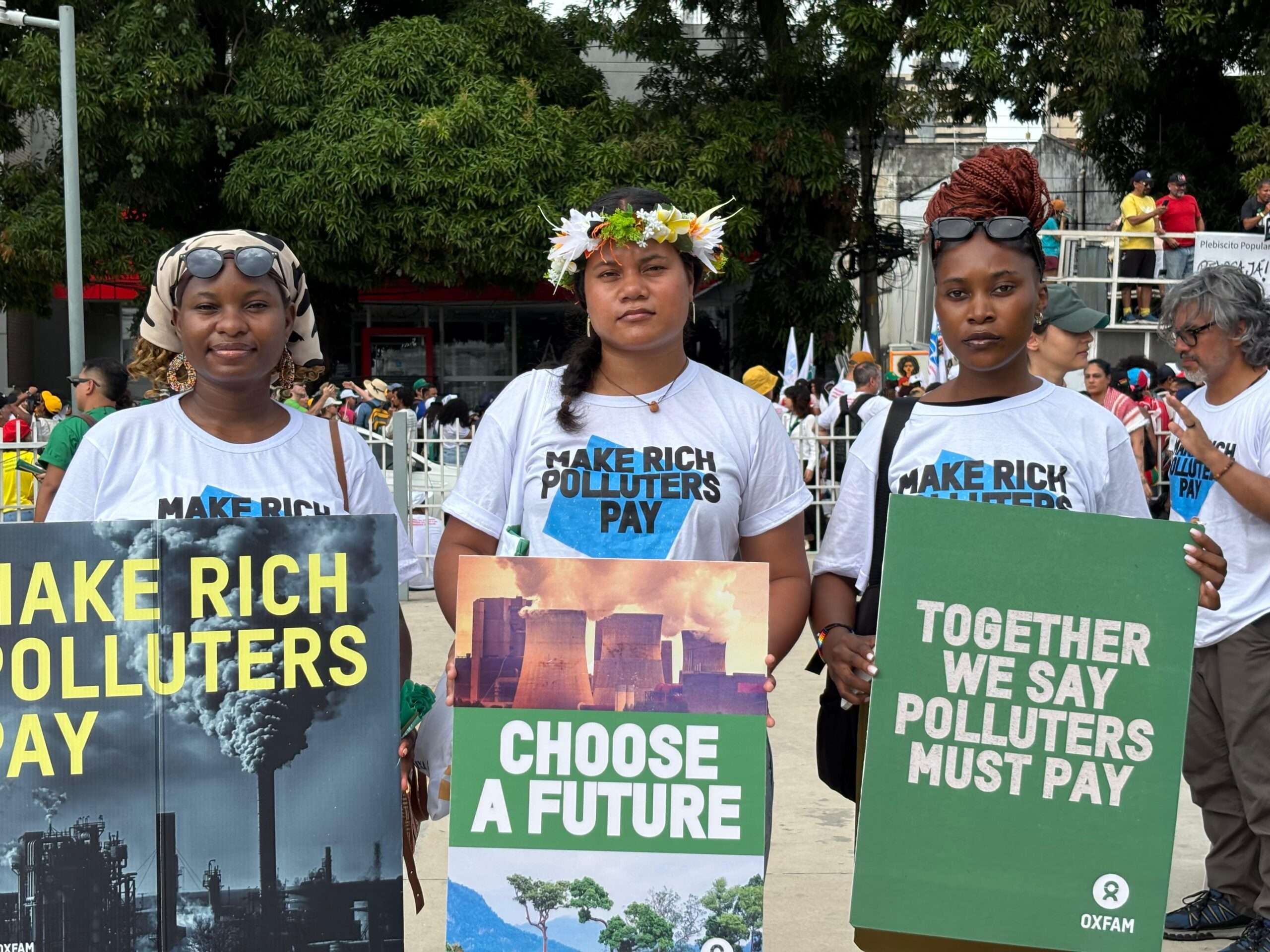 Three Oxfam Cimate Justice Activists at the street March in Bele, fighting to make rich polluters pay