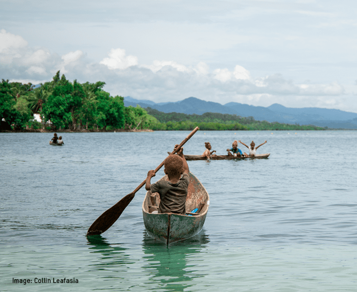 Image of children rowing small boats against a blue sea and sky backdrop.