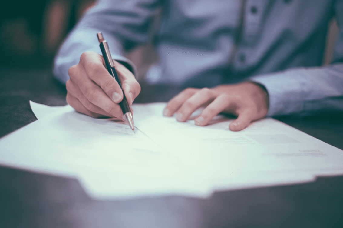 person signing paper