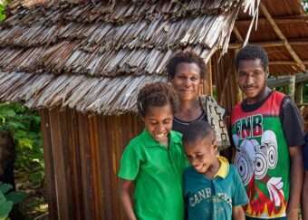 A family stand together smiling