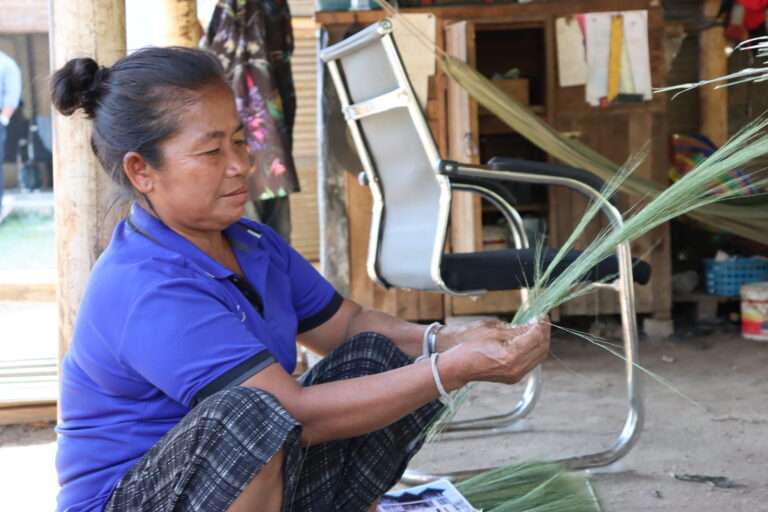 Woman making traditional brooms in Laos