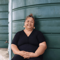Teisa Alifeleti (48) sits next to the water tanks that serve Pangai district in low-lying Ha’apai Island in Tonga.