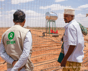 Two men in in barren conditions discussing drought response in Somalia