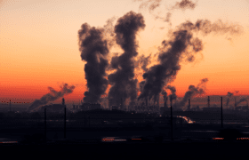 factory bellowing smoke into atmosphere